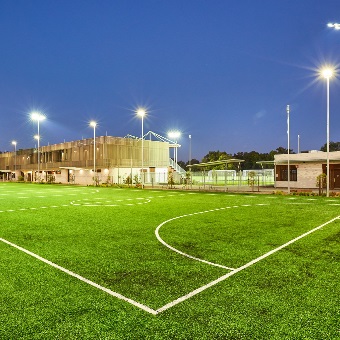 A photo of one of the three five a side pitches at the Sam Kerr Football Centre in Queens Park, Perth with the main building in the backdrop