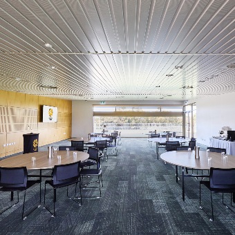 A photo of multiple tables set up around a lectern in a meeting room at the Sam Kerr Football Centre in Queens Park, Perth