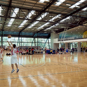 A photo of Perry Lakes Hawks basketball players warming up on court at the Bendat Basketball Centre