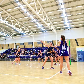 A photo of netball being played indoors at the Gold Netball Centre in Jolimont, Perth