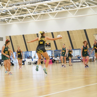 A photo of netball being played on one oof the indoor courts at the Gold Netball Centre in Jolimont, Perth