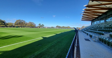 A photo showing the grandstand and side of one of the pitches at the Sam Kerr Football Centre in Queens Park