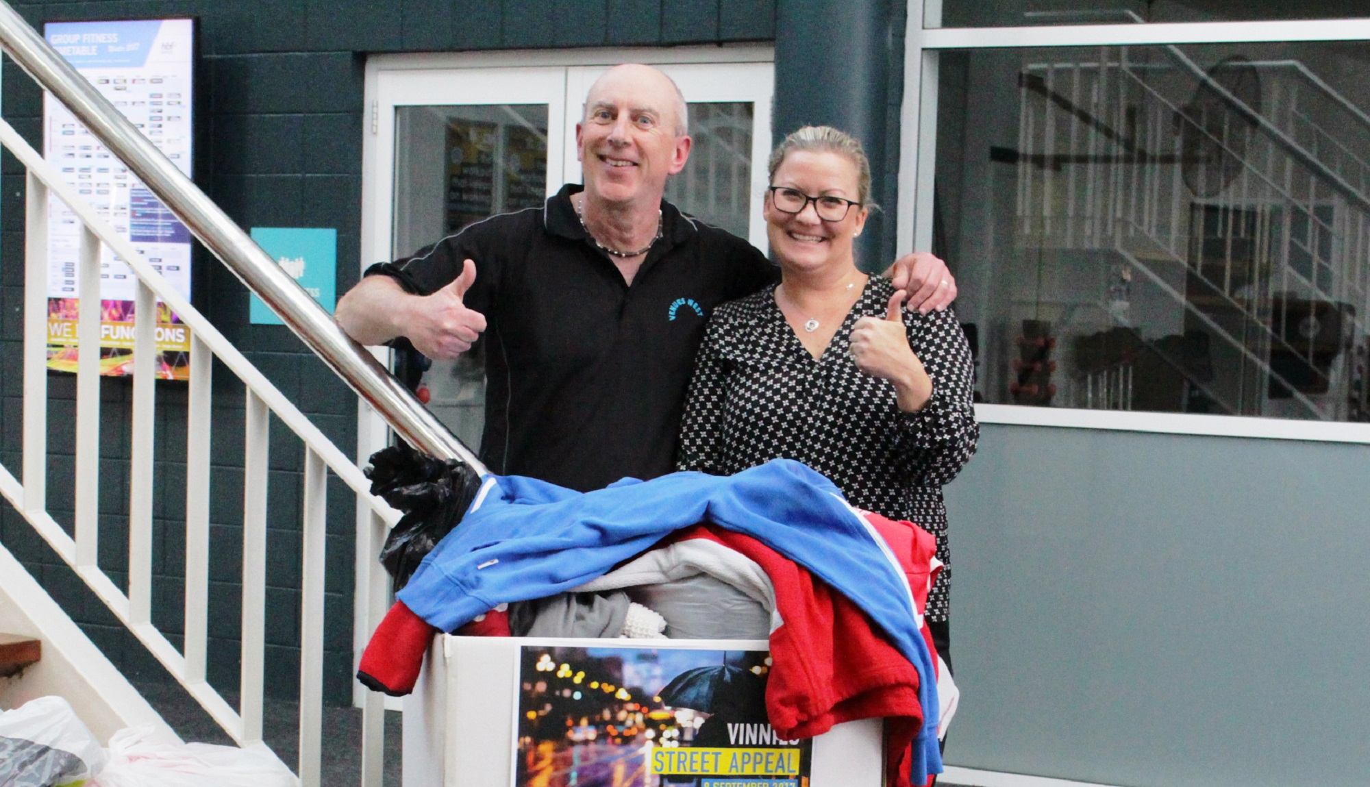 Photo of two people next to a staircase from St Vinnies
