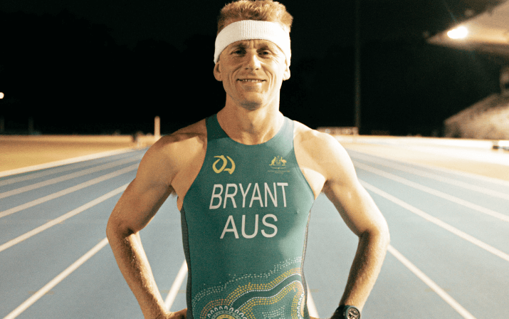 Close up photo of David Bryant at the WA Athletics Stadium in Mount Claremont, Perth Close up photo of David Bryant wearing a headband and an Australian singlet standing on the track at the WA Athletics Stadium in Mount Claremont, Perth