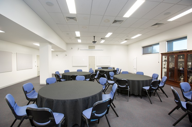 A photo of several tables and chairs set up in a function room